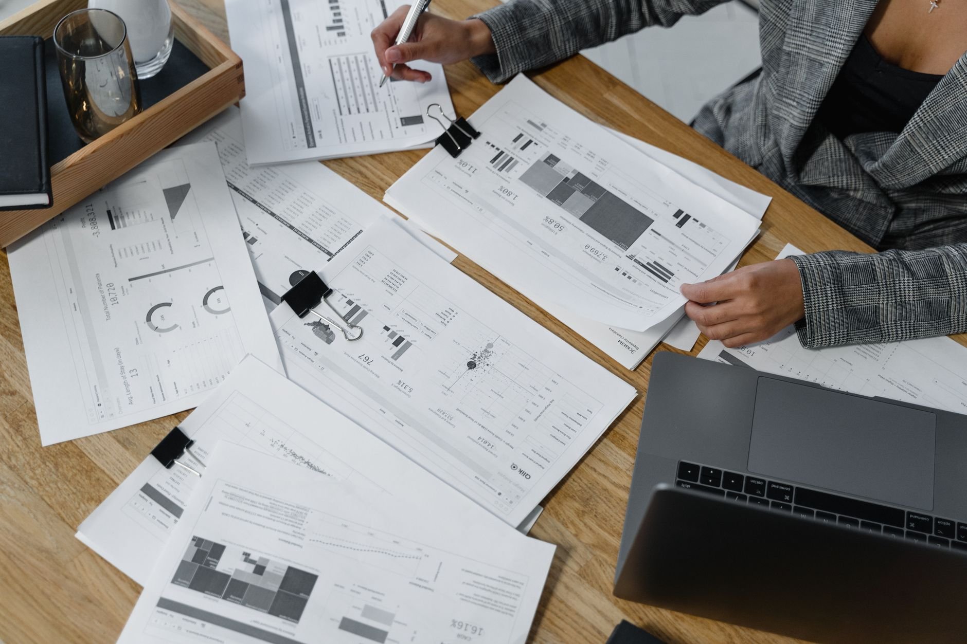 Financial documents and reports organized on a desk with a laptop